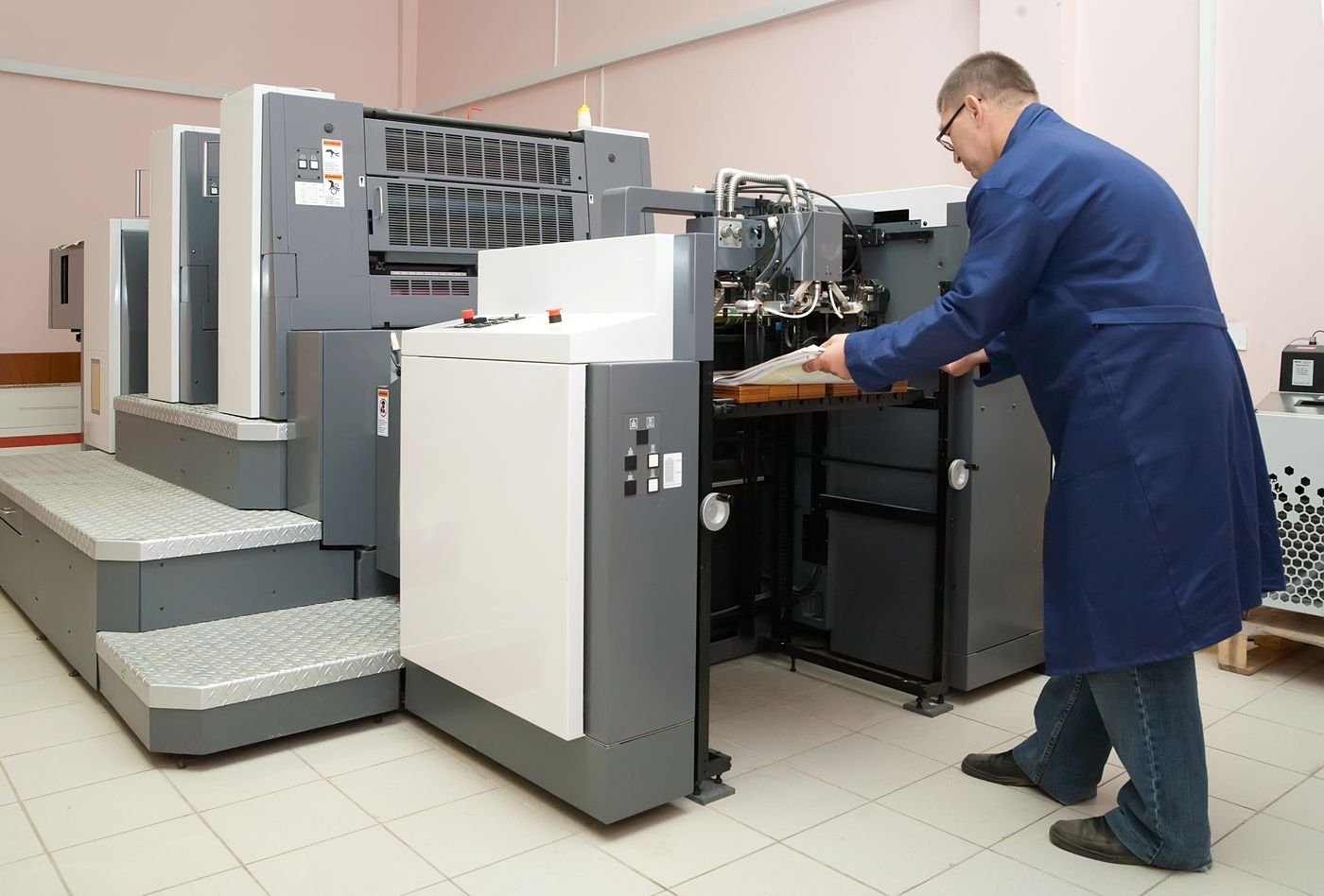 Técnico a operar uma impressora offset na gráfica